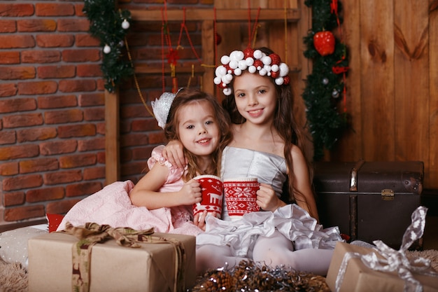 Meninas com copos de malha de Natal