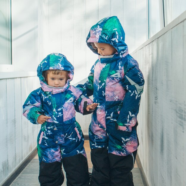 Meninas com o mesmo macacão quente. roupas de inverno para crianças de todas as idades