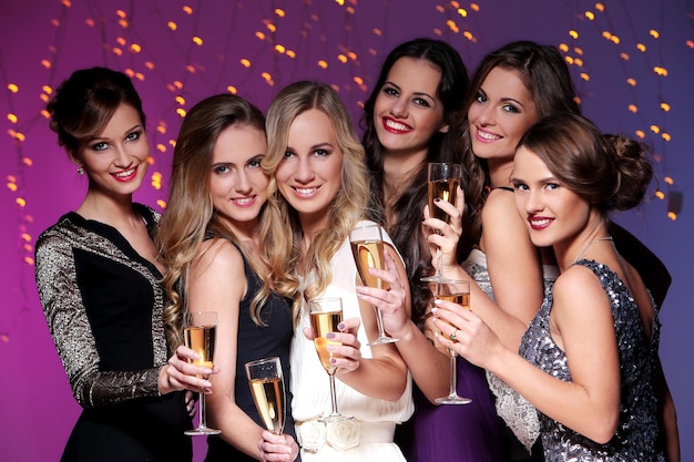 Meninas com uma taça de champanhe comemoram o ano novo