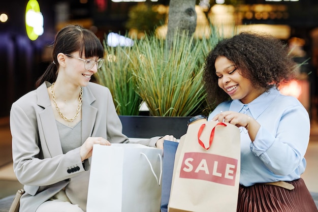 Foto meninas compartilhando compras no shopping