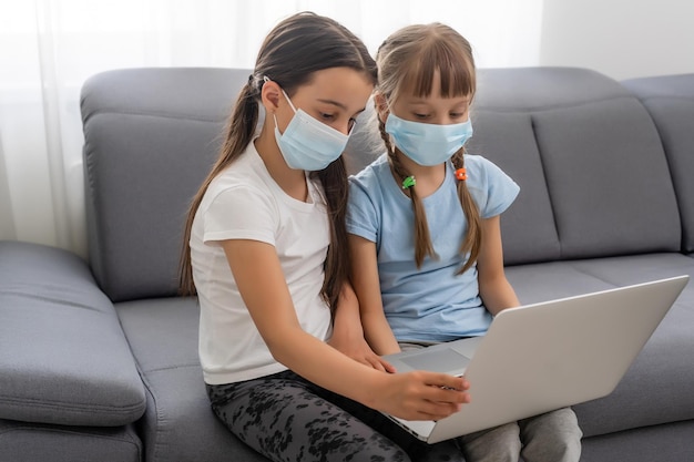 Meninas da escola estudando em casa usando máscara, aprendizado à distância.