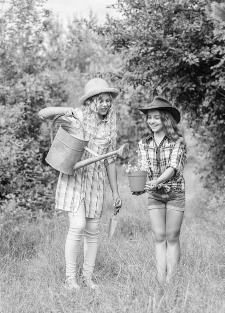 Meninas de chapéu plantando plantas Fundo de natureza de crianças rústicas Crianças se divertindo na fazenda Conceito de agricultura ecológica Plantando e regando Conceito de agricultura Irmãs ajudando na fazenda Fazenda familiar