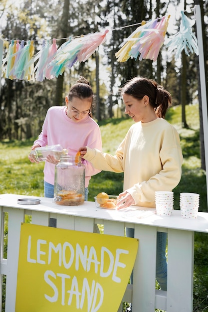 Meninas de tiro completo fazendo limonada juntos