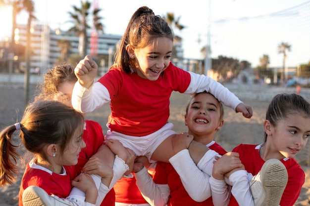 Foto meninas de tiro médio carregando companheiro de equipe