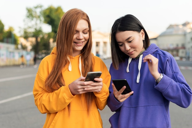 Foto meninas diferentes checando seus telefones