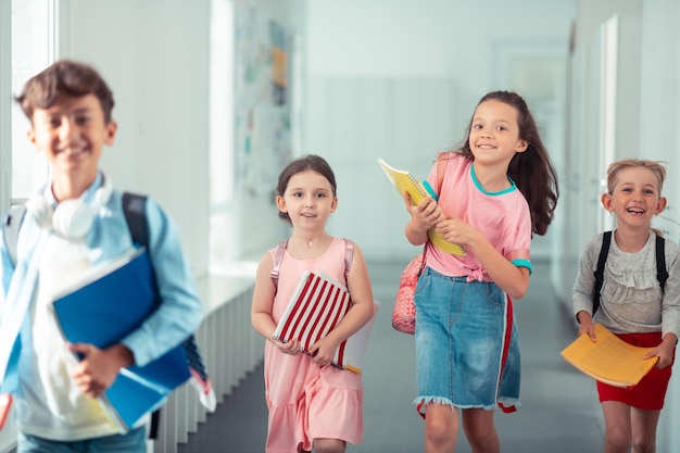 Meninas e menino se sentindo feliz indo para casa da escola