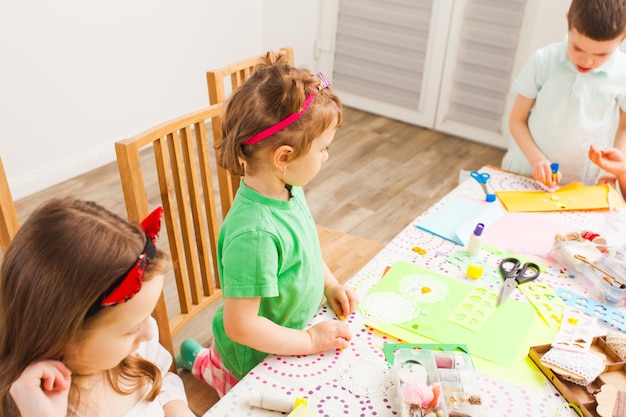 Meninas e um menino participam de oficina e fazem cartões de felicitações