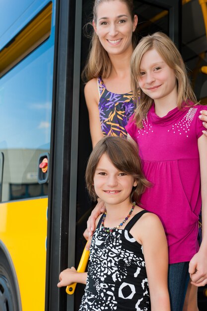 Meninas em um ônibus com sua mãe