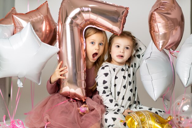 Meninas em vestido de noite, olhando para fora de um balão em forma de um sete