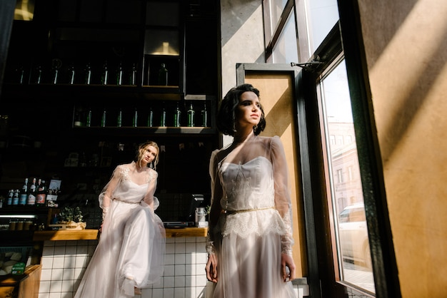 Meninas em vestidos de noiva branco estão posando.