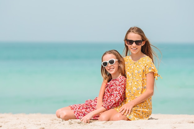 Meninas engraçadas felizes se divertem muito na praia tropical tocando juntos.