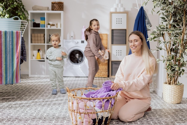 Meninas estão brincando na lavanderia do banheiro dançando correndo enquanto a mãe está ocupada