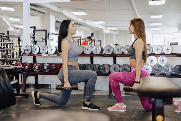 Meninas fazem halteres no ginásio, fitness