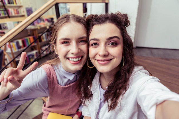 Meninas fazendo foto. garotas lindas e fofas com pele impecável fazendo selfie de perto e mostrando seus rostos