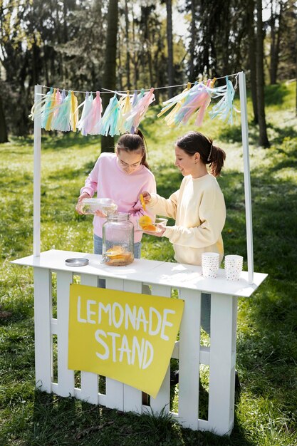 Meninas fazendo limonada juntos tiro completo