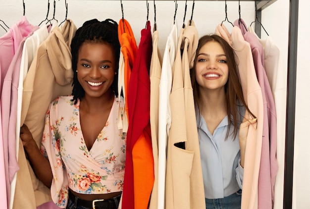 Meninas felizes no mercado de pano semanal se divertindo e fazendo compras juntos