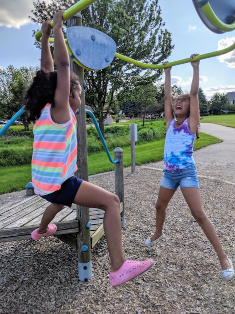 Foto meninas felizes penduradas no ginásio da selva.