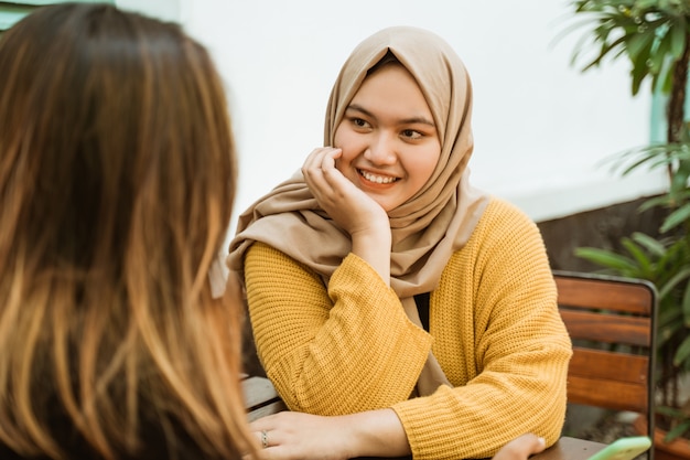 Meninas Hijab vêem amigos enquanto conversam