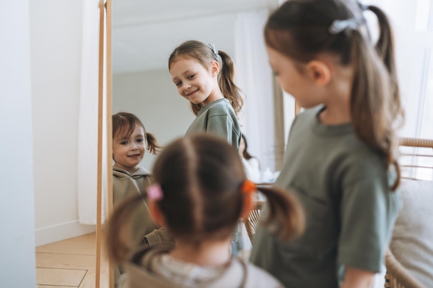 Meninas irmãs bonitinhas olhando no espelho em casa