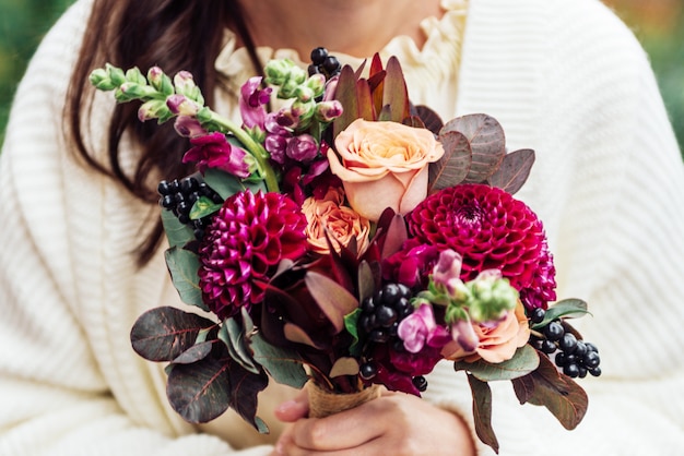 Meninas mãos segurando buquê de flores em estilo boho rústico