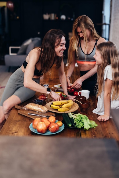 Meninas na cozinha falando sobre cozinhar refeições fáceis de frutas e legumes