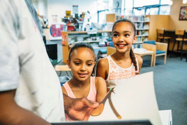 Meninas olhando livros na biblioteca pública