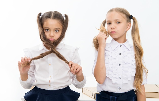 Meninas pequenas com penteado de cauda As crianças precisam de um novo penteado no salão de cabeleireiro meninas pequenas de volta à escola