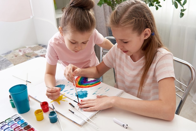 Meninas pintando nas unhas com aquarela se divertindo