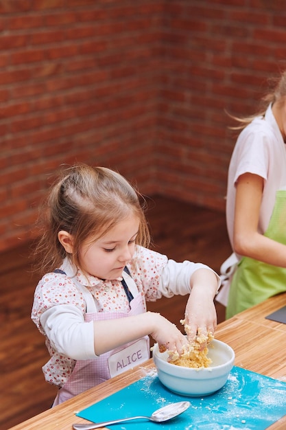 Meninas preparando comida na cozinha em casa