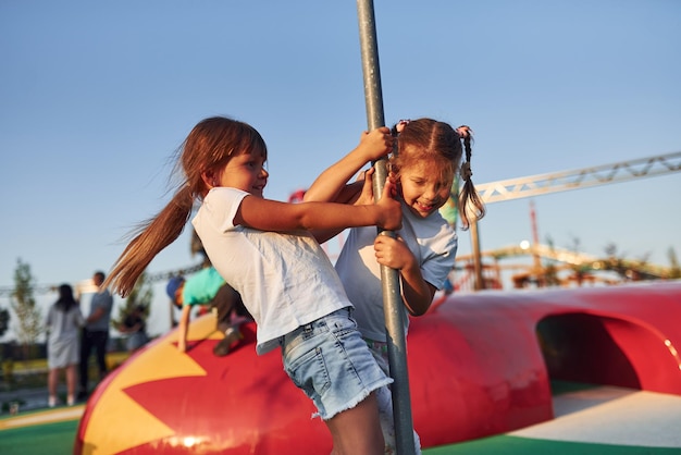 Meninas se divertem no parque de diversões infantil durante o dia