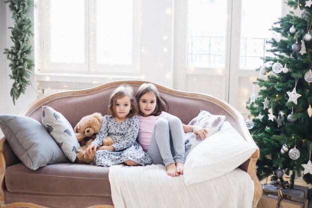 Meninas sentadas no sofá em casa no Natal