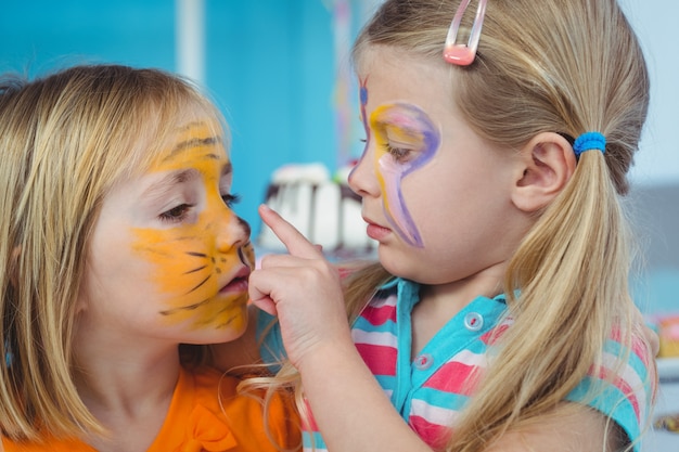 Meninas sorridentes com os rostos pintados