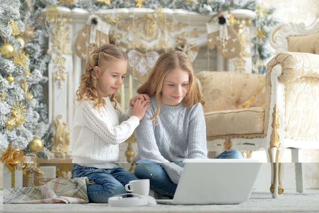 Meninas usando laptop em casa no Natal