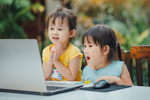 Meninas usando o computador portátil