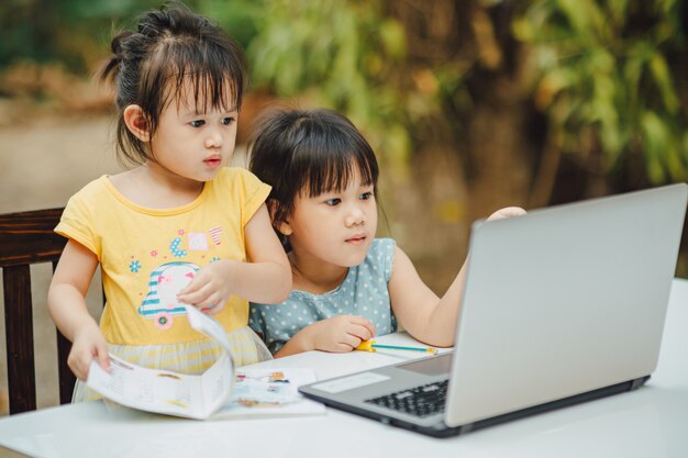 Meninas usando o computador portátil