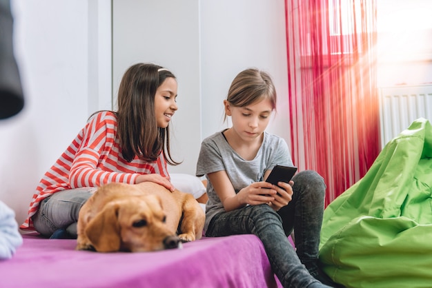 Meninas usando telefone inteligente