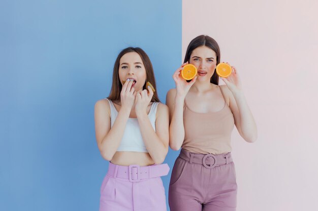 meninas vestindo roupas de verão, elas estão se divertindo e brincando com frutas suculentas