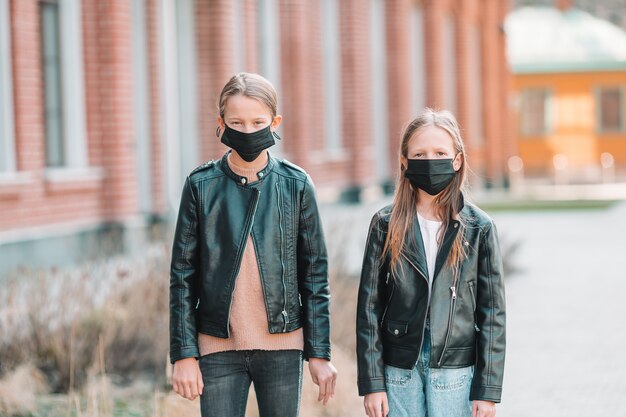 Meninas vestindo uma máscara em um fundo de um edifício moderno,