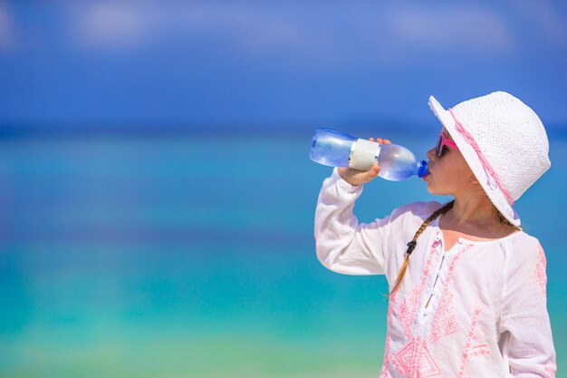 Menininha, bebendo, garrafa mineral água, em, dia quente verão, ligado, praia