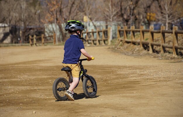 Menino a andar de bicicleta no campo