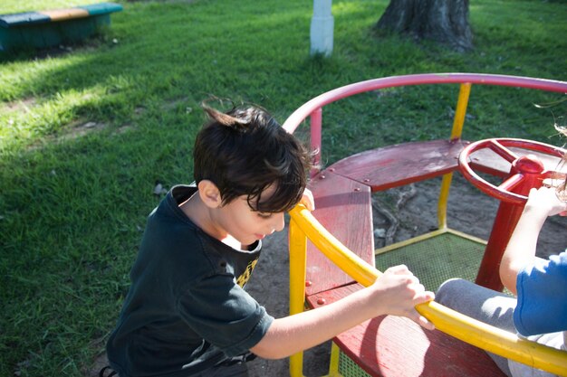 Menino a divertir-se no parque infantil