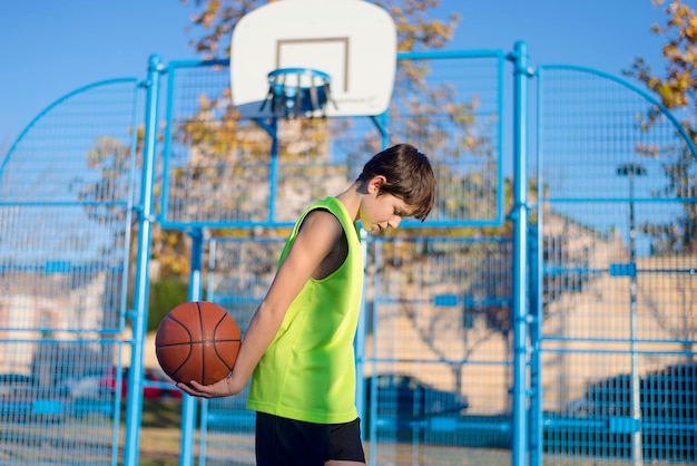 Foto menino a jogar basquetebol no campo.