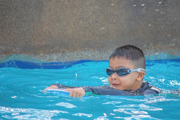 Foto menino a nadar na piscina .