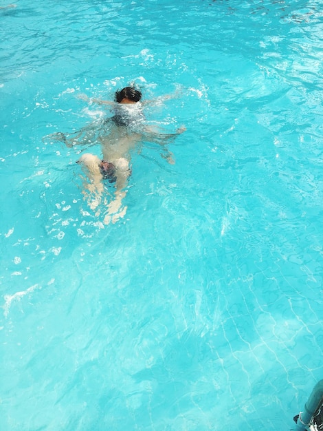 Foto menino a nadar na piscina .