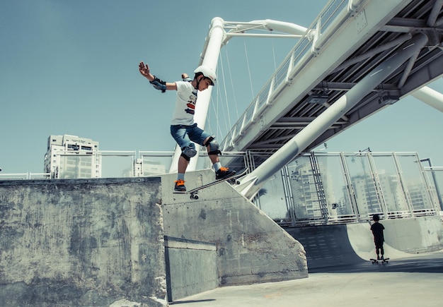 Menino a patinar no parque contra um céu claro