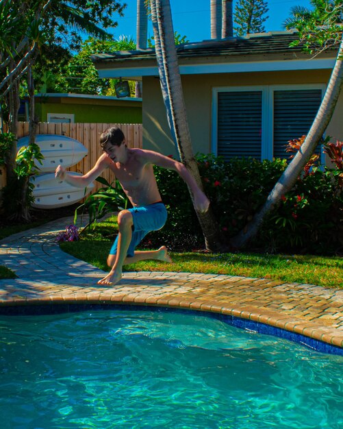 Foto menino a saltar na piscina.