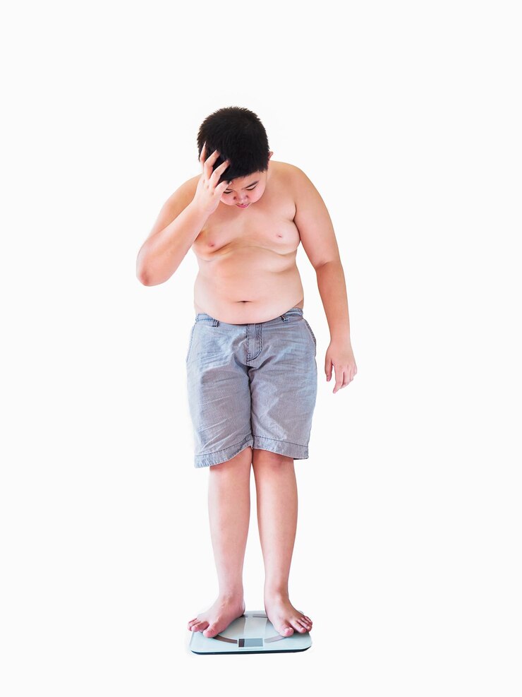 Foto menino adolescente sem camisa de pé na balança de peso contra fundo branco