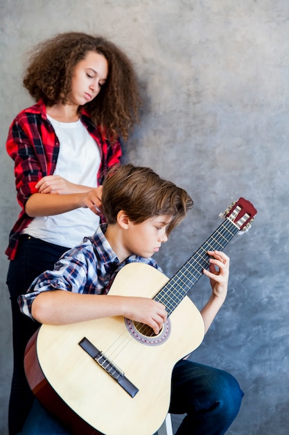 Menino adolescente, violão jogo, enquanto, menina adolescente, escutando, ele