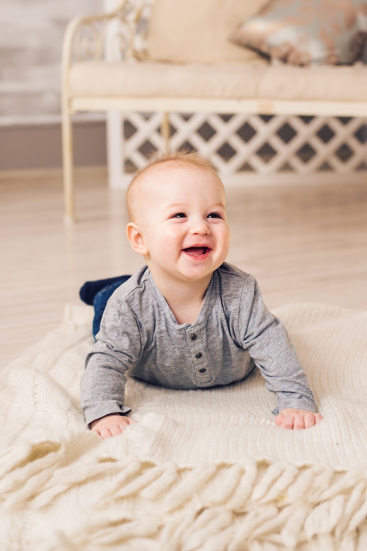 Foto menino adorável no quarto ensolarado. criança recém-nascida relaxante. manhã em família em casa. criança recém-nascida durante o tempo de barriga.