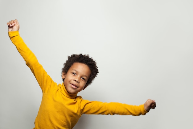 Menino afro-americano brincalhão em fundo branco